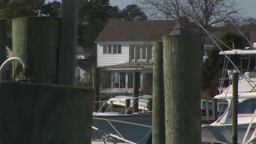 Back zoom from waterfront homes to marine fueling pump station boat dock in Wachapreague, Accomack county Eastern shore of Virginia, USA