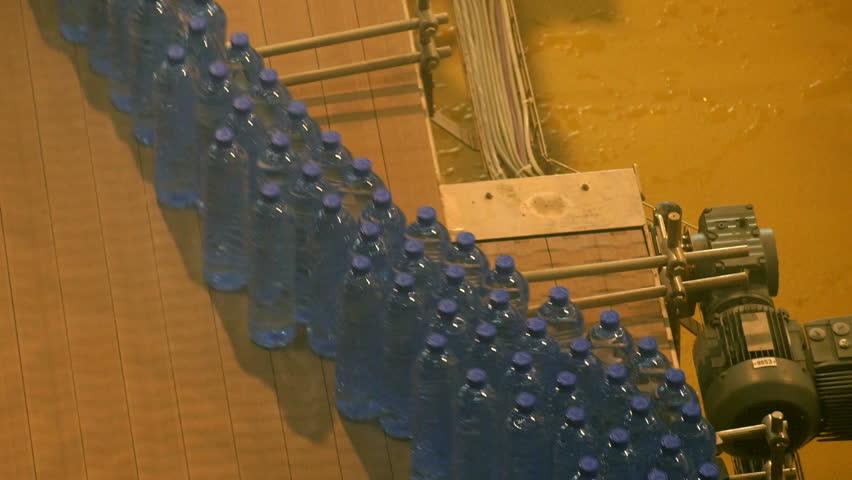 Blue plastic bottles on a assembly line in a drinking water factory | Shutterstock HD Video #17034661
