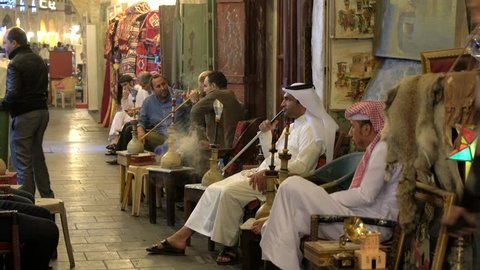 Doha, Qatar - February 2016: Men smoking Sheesha or water pipes in cafe at Souq Waqif, Doha, Qatar