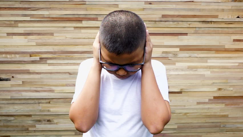 A young Asian boy looking sad, scared and depressed