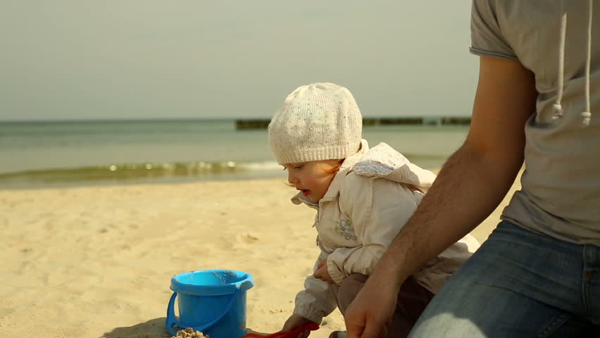 Father and daughter plays at the beach
