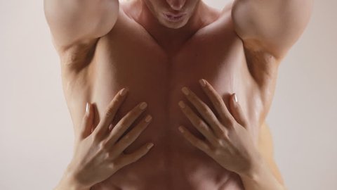 Hands of young woman touching athletic torso with abs of man. Ungraded