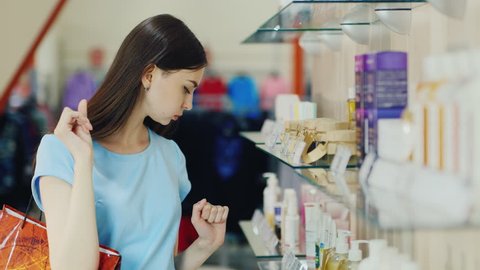 Attractive brunette chooses liquid soap in a perfume shop
