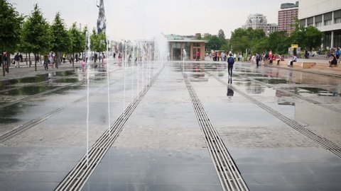Water jets of dry fountain in area of park Muzeon and people around.