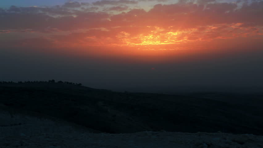 Still shot across desert hill tops with a vibrant orange  Israeli sunset.