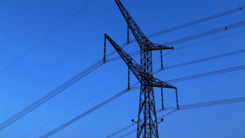 The top of a electrical transmission tower and overhead power lines under the