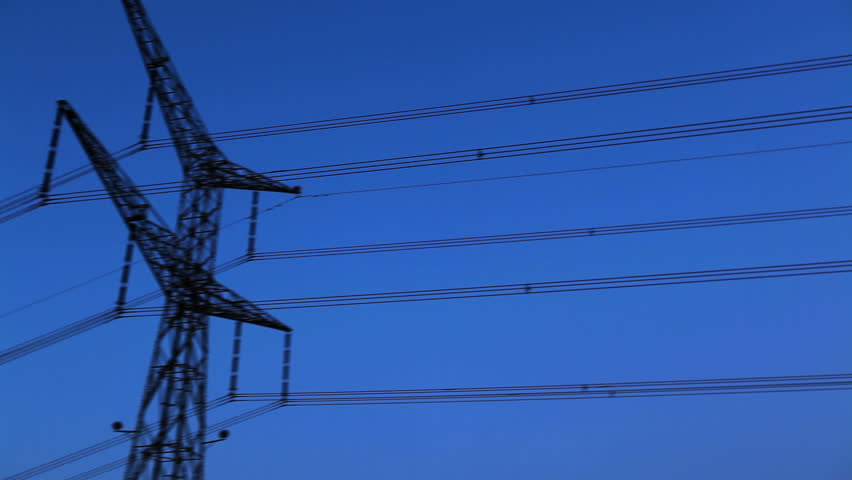 Pan right to left along overhead power lines to the top of an electrical