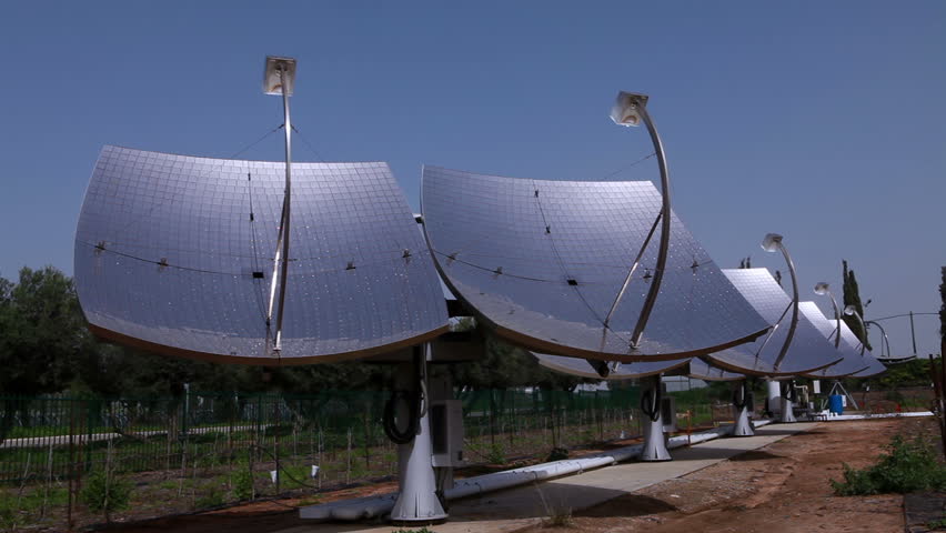 Row of solar panels with the first row of trees in an orchard in the background