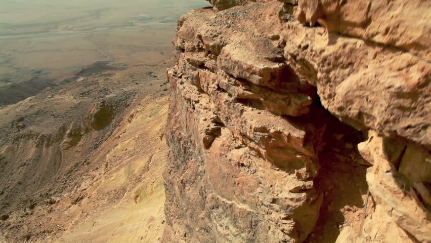 Wide dolly slider move up the cliff face and to the ledge of the Mitzpe Ramon