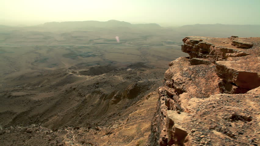 Slider dolly shot out and over the cliff face of the Mitzpe Ramon Crater in