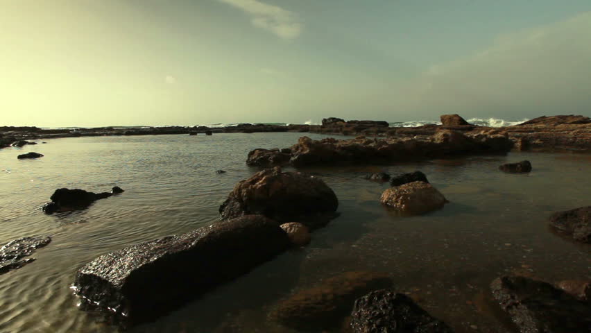Low angled shot at Caesarea in Israel of the rocky ruins on the beach of the