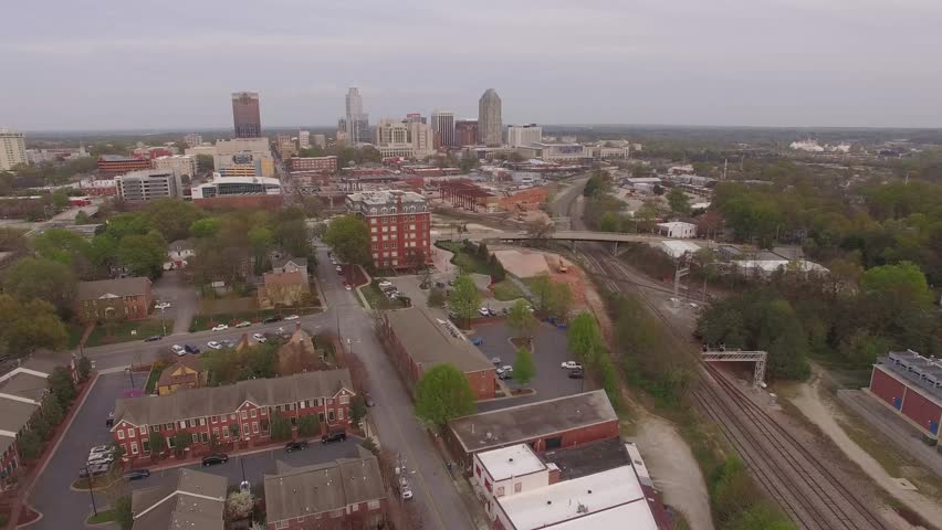 Flying backwards above Raleigh, NC facing the downtown skyline.