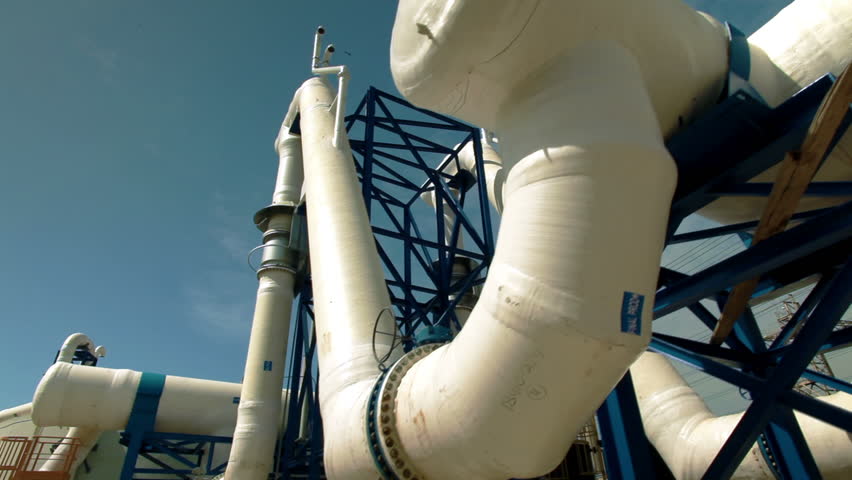 Slider dolly move along jungle gym of huge white water desalination pipes at the