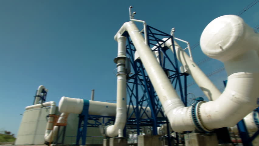 Wide pan, left to right, along jungle gym of huge white desalination pipes at