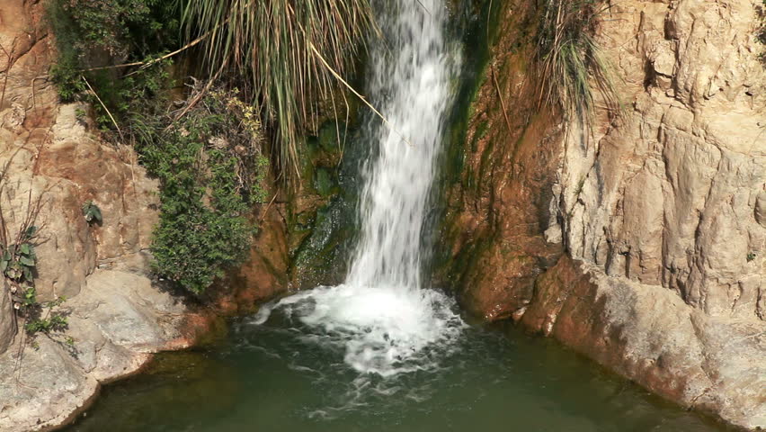 Angled medium shot of a waterfall from the Ein Gedi Nature Reserve in Israel