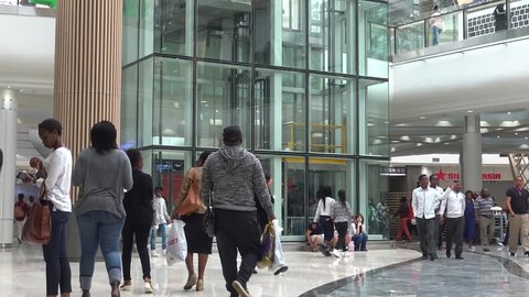 JOHANNESBURG, SOUTH AFRICA - 7TH MAY 2016: Hundreds of shoppers of various ethnic backgrounds walk through the newly opened Mall of Africa in Johannesburg. An elevator can be seen in the background.