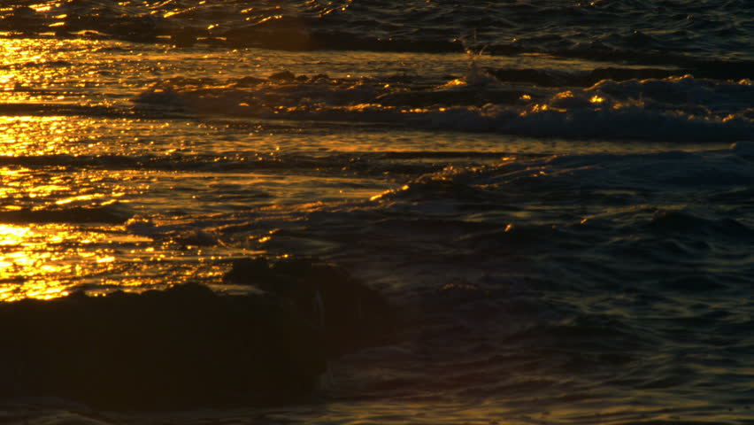 Golden shot reflecting the sunset off the Mediterranean waves lapping over large