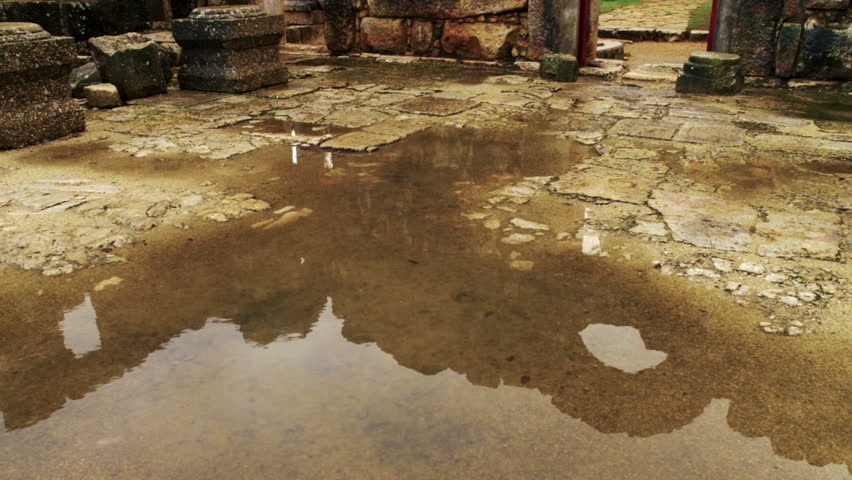 Pan across pool of rain water collected on the floor of the ruined synagogue at
