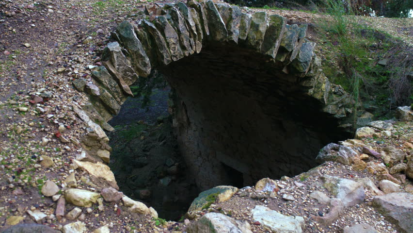 A static shot of an archway looking down to an under ground area with an entry