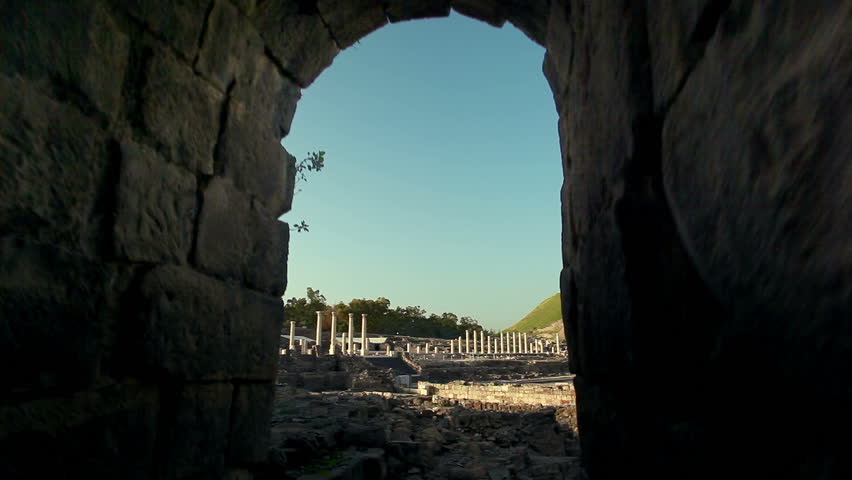 Slider dolly shot moving down and out of an archway from the ancient theater at