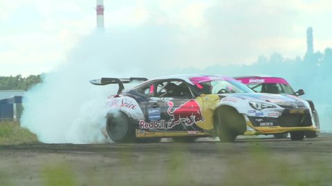 MOSCOW, RUSSIA - MAY 15, 2016 : Slow motion shot of cars drifting with lots of smoke during drift competition in Moscow, Russia on a sunny summer day. 