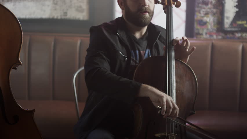 Medium panning shot of strings trio playing in bar / Salt Lake City, Utah, United States