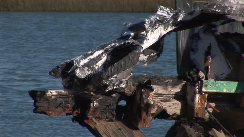 Close up of remains of old burned fishing boat abandoned on edge of lagoon in marshland in Wachapreague, Accomack county Eastern shore of Virginia, USA  