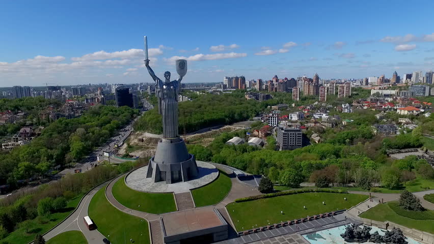 Camera Flies Over a Monument to the Birthplace of His Mother. Kiev in May 2016. the Prospect of the City of Kiev at Home Car Road. the Motherland Calls the Shield and the Sword. Day Summer Sky Clouds