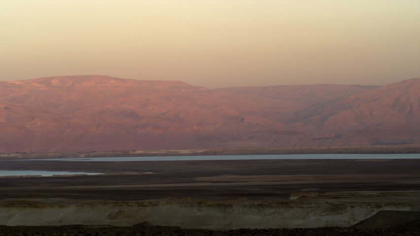 Pan right to left of the Jordanian mountains at sun set with the dead sea at the