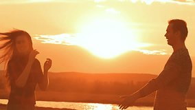 a man and a woman dancing at sunset slow motion video