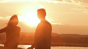 a man embraces the girl on a sunset background Slow motion video