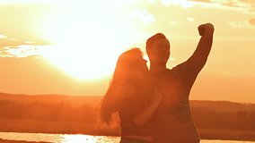 at sunset man and woman hugging slow motion video