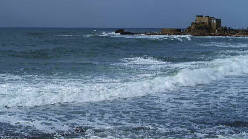 Pan from left to right following the Mediterranean waves off the coast of