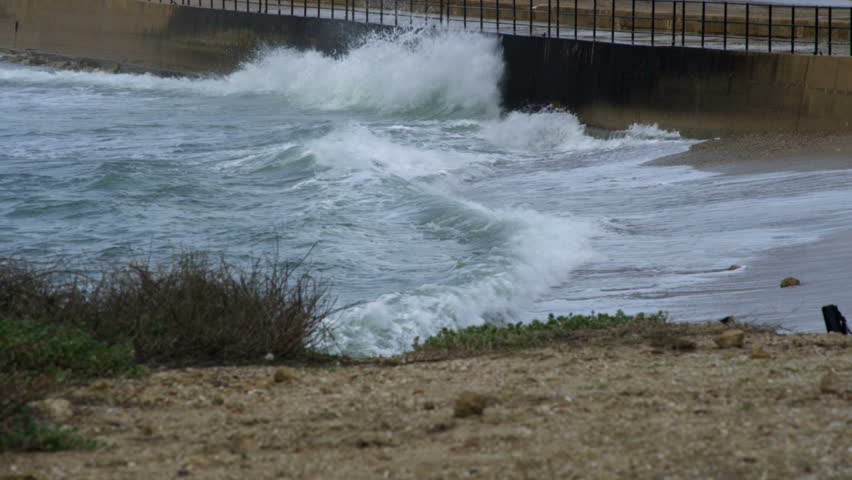 Mediterranean waves crashing into the retaining wall protecting some of the