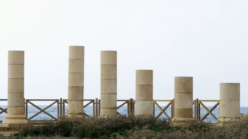 Columns of the palace ruins in Caesarea Israel, in front of a fence barrier and