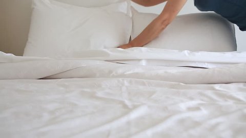 Asian woman making bed 