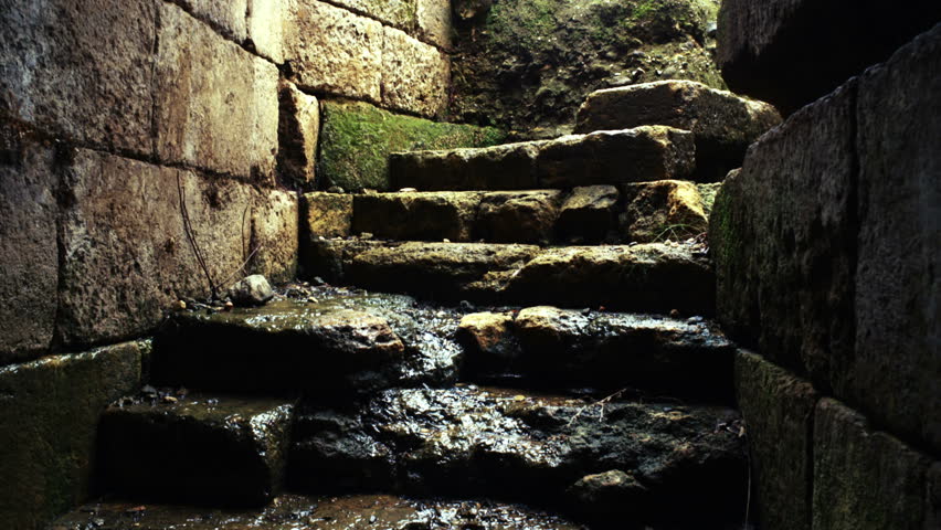 Closeup of rain water trickling down the steps leading to an underground
