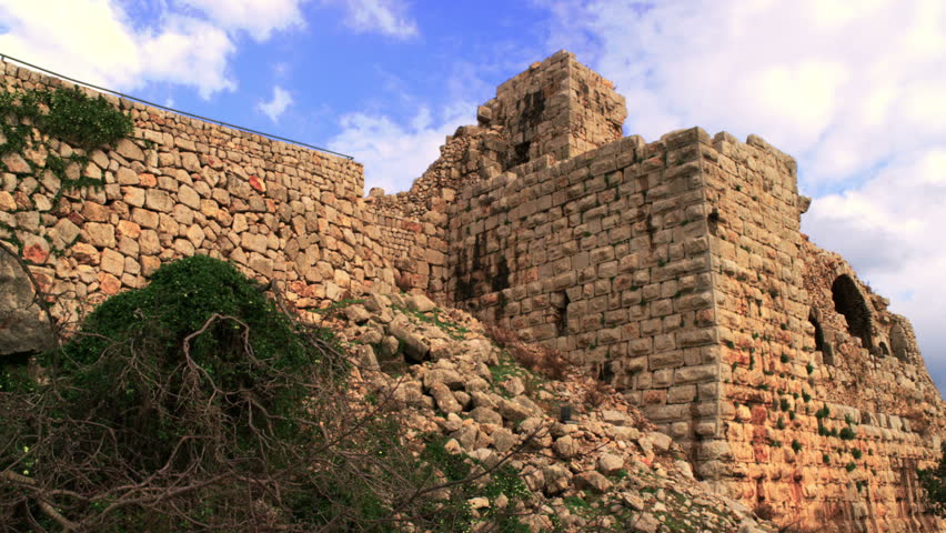 Slow pan, looking up, across the base of the Nimrod Fortress in the Golan