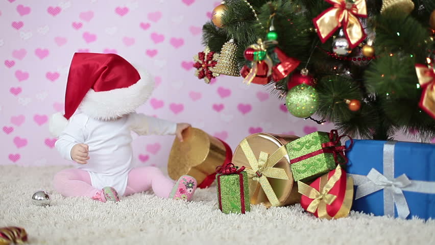 Santa prepares the gifts near the Christmas tree 