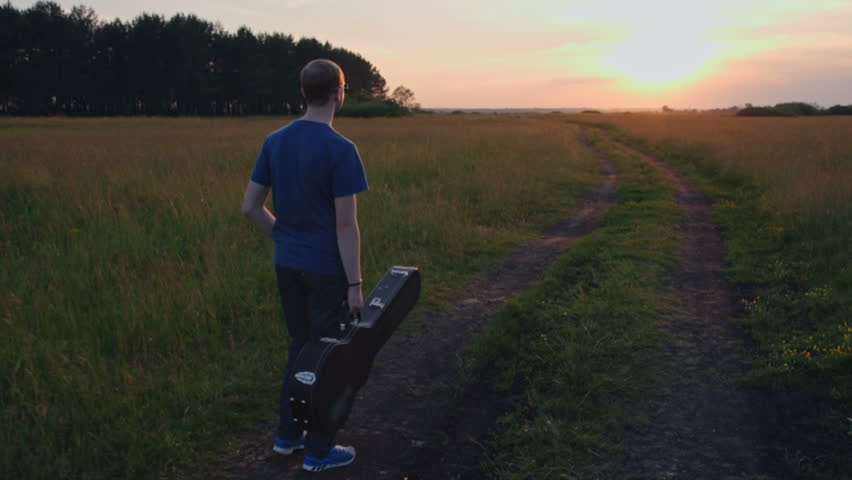 Young Man Walking with Guitar, slow motion