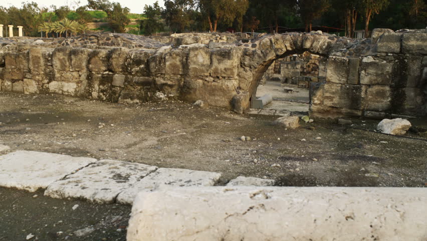 Dolly left to right of a stone wall and archway of the ruins left from the Roman