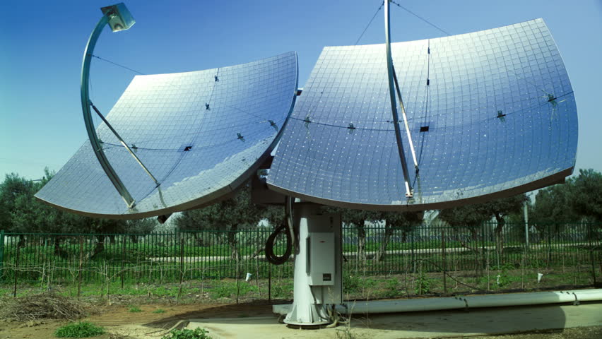 Slow tilt up two solar panels with a tree orchard in the background at the