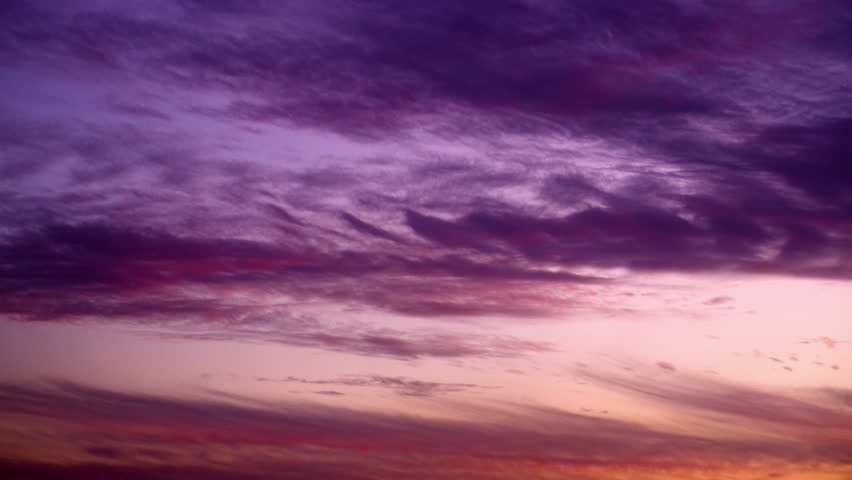 Clouds, fast moving with purple, pink, blue and the reddish hues of a deep