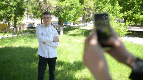 KHERSON, UKRAINE - MAY 05, 2016: Beautiful young friends boy and girl doing selfie photos on mobile phone in park