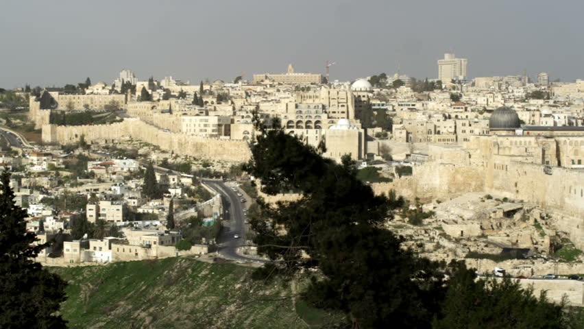 Wide shot panning across the wall of Old Jerusalem in Israel from the Mount of