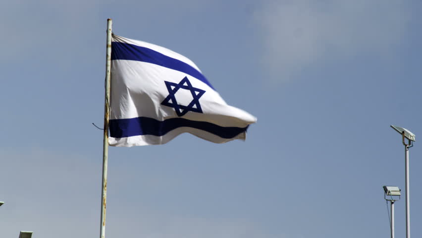The Israeli flag waving in the wind above the grounds at the Western Wall