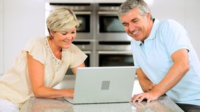 Mature Couple Using Wireless Laptop in Home Kitchen - Powered by Shutterstock - Get 15% off with code: PIKWIZARD15