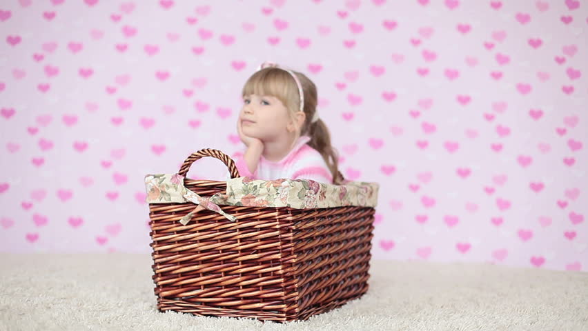 Child sitting in a basket and looking at camera 