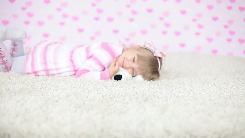 Happy baby on the carpet with teddy bear 