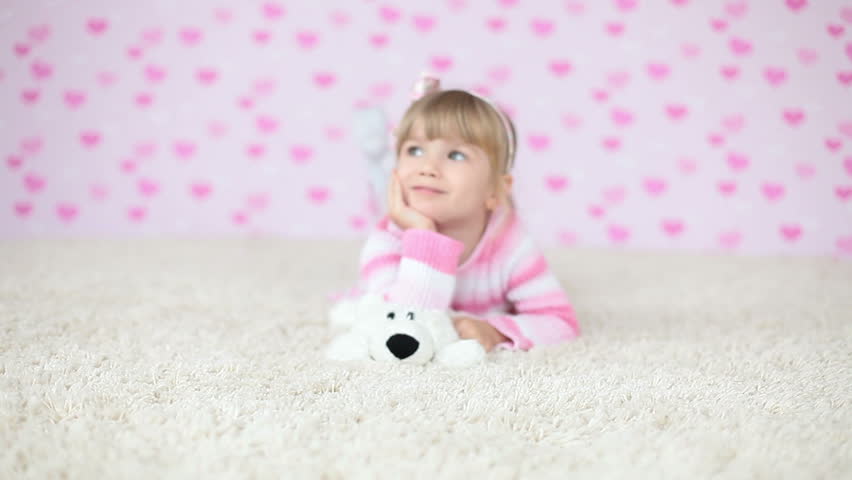 Happy girl relaxing lying on the carpet 